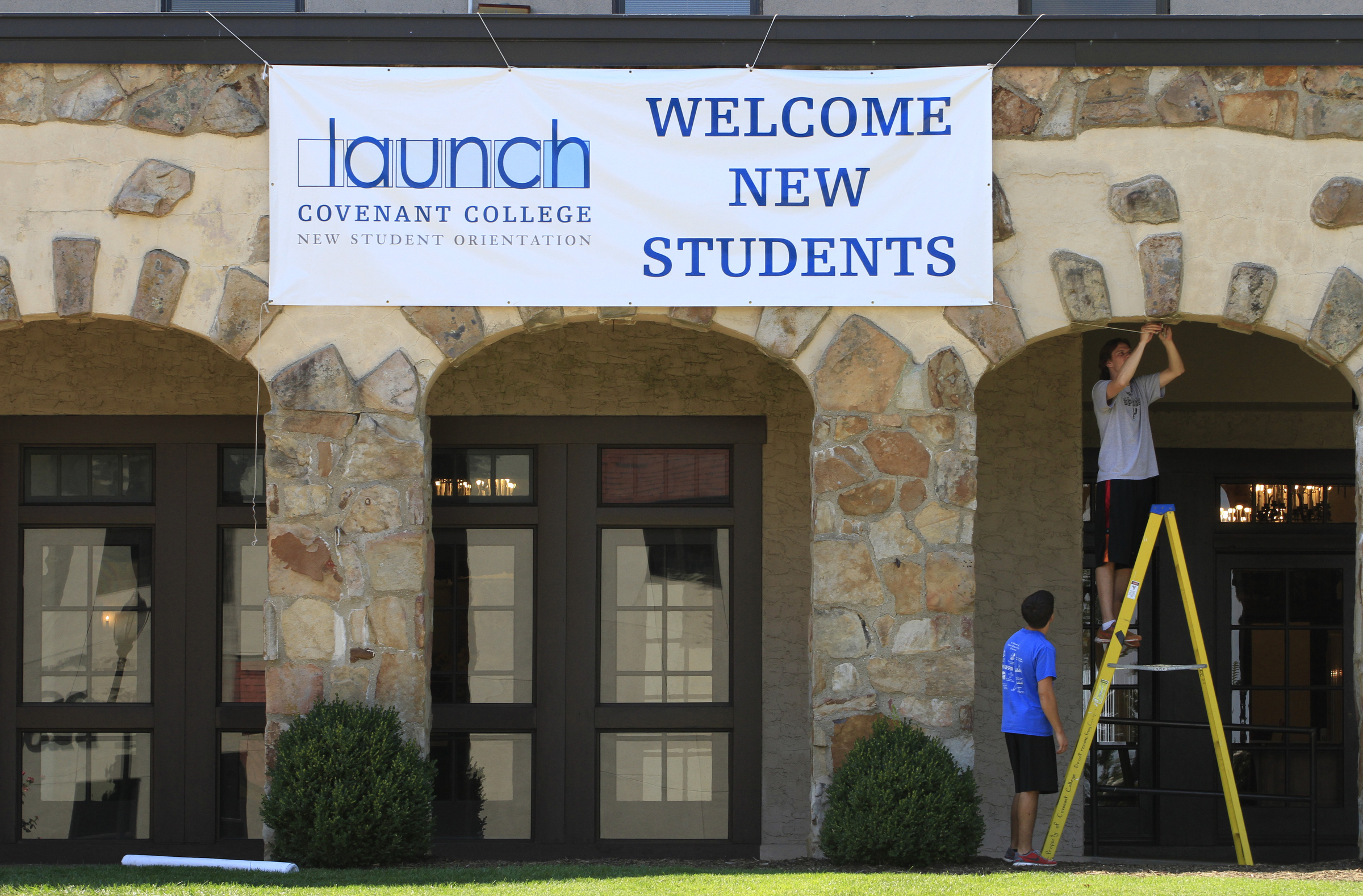 Staff Photo by Dan Henry/Chattanooga Times Free Press - 8/20/12. Junior classmen and facilities service employees Caleb Elliott, left, and James Leithart hang banners at Covenant College atop Lookout Mountain in preparation for classes which begin Thursday.
