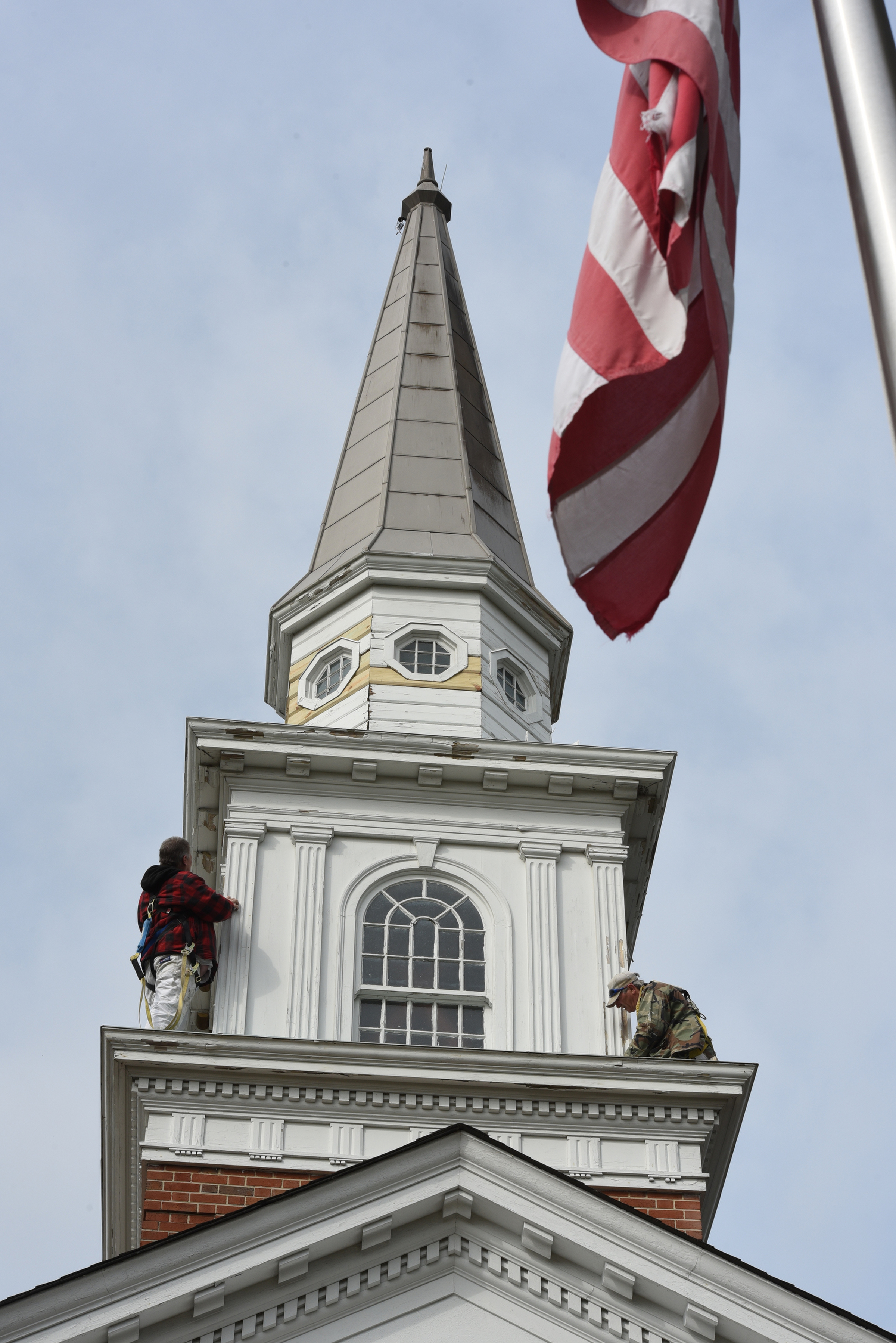 Rodney Youngblood and Craig Thomas, of Youngblood Painting, scrapes the steeple section to prepare for fresh white paint on Monday high atop the Lookout Mountain United Methodist Church at Lula Lake Road and Red Riding Hood Trail. Youngblood says it should take at least a full week to paint all the white trim on the stately building.