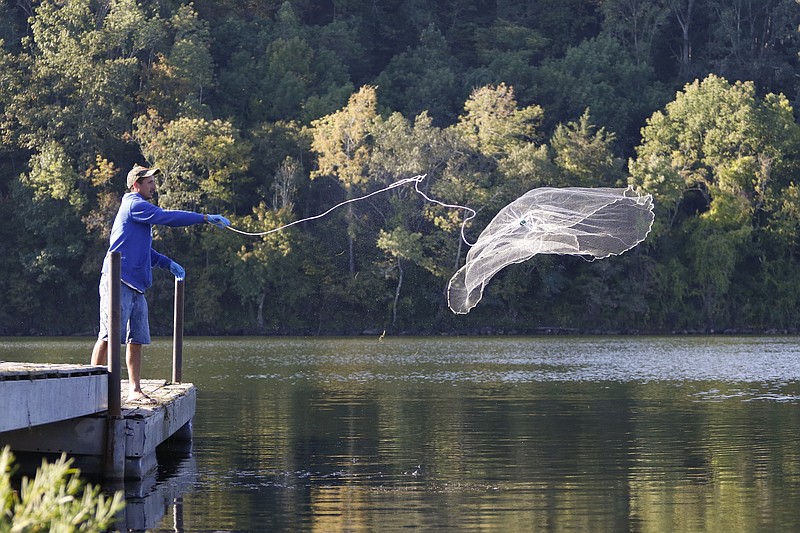 Staff Photo by Dan Henry / The Chattanooga Times Free Press- 9/22/15. Nick Poveromo uses a net to catch bait while fishing off of a pier near Harrison Bay on Tuesday, September 22, 2015. 