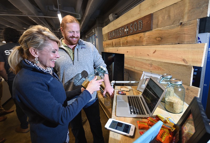 Kelli Munczenski, left, and Matthew Killebrew, of Sawdust + Sod, stand at their booth prior to the Company Lab's Pitch Night in the Edney Building Wednesday. Taylor Davidson, also with the company, is not pictured.