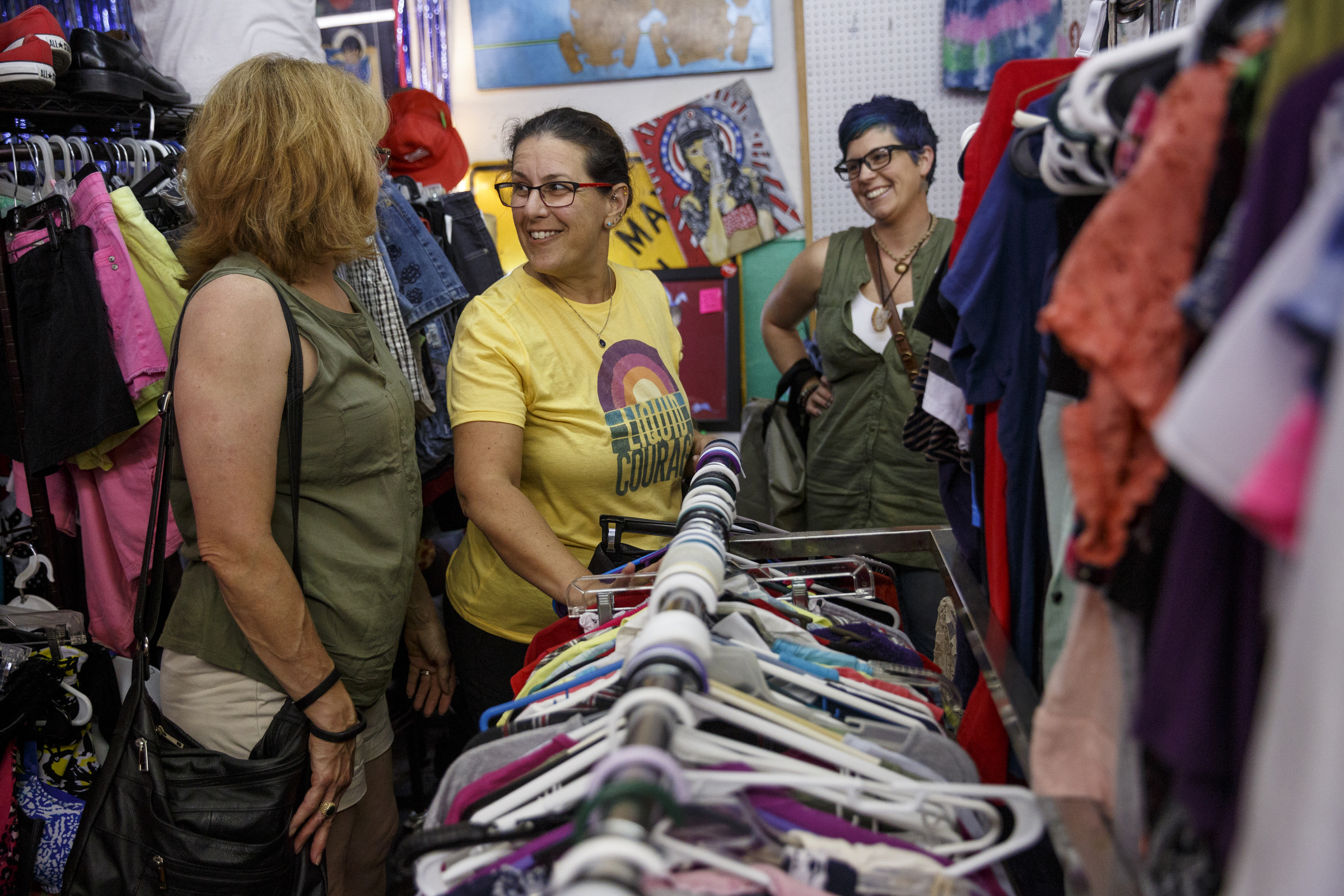 Jody Simon, center, talks with Tracy Busbee, right, and Jeannette Davis as they put clothes on a rack for a clothing swap party at Bettieville in Rossville.
