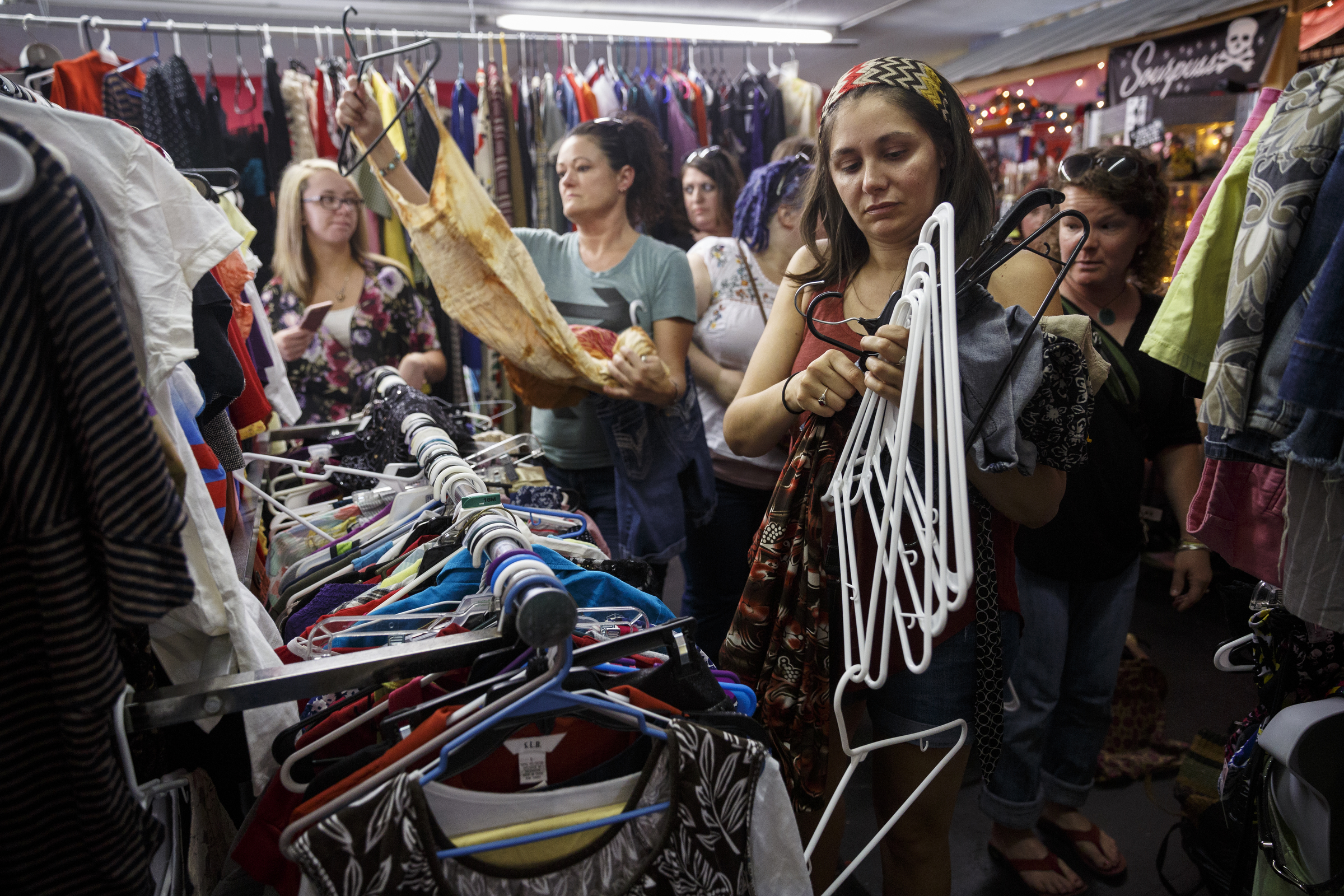 Lisa Pepper organizes clothes hangers as people pick out articles of clothing they like during a clothing swap party at Bettieville. Customers arrive with items to for the swap and get to take home different clothes and accessories.