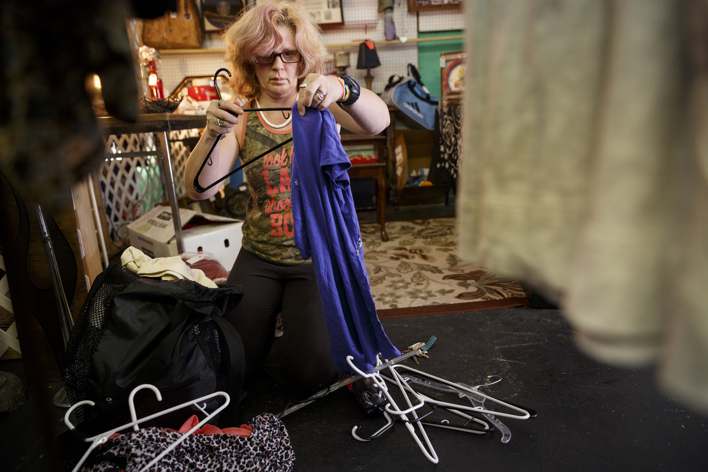 Emily Flanagan hangs up clothes she brought for a clothing swap party at Bettieville in Rossville.