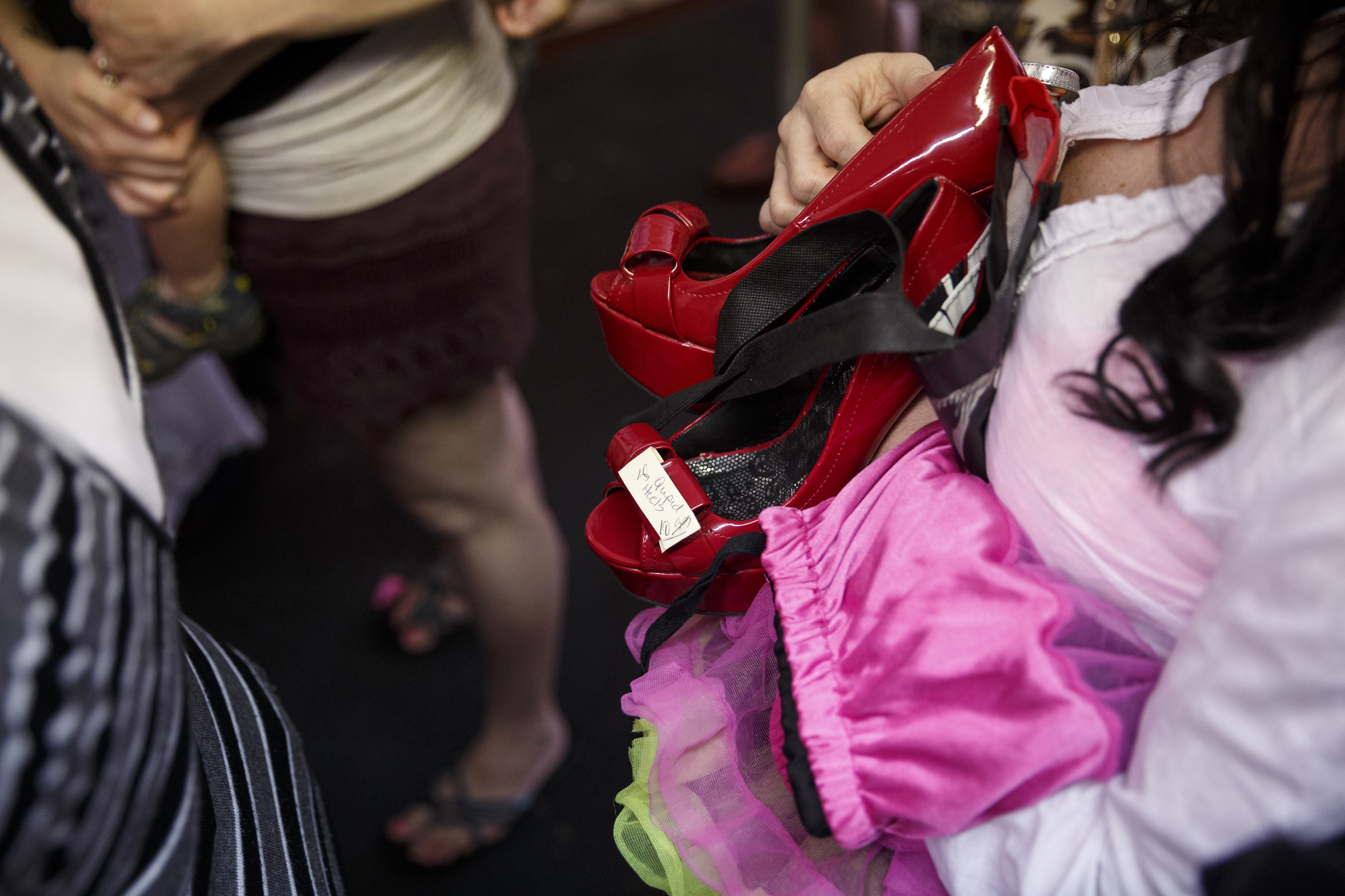 A woman holds a pair of heels brought for a clothing swap party at Bettieville in Rossville.