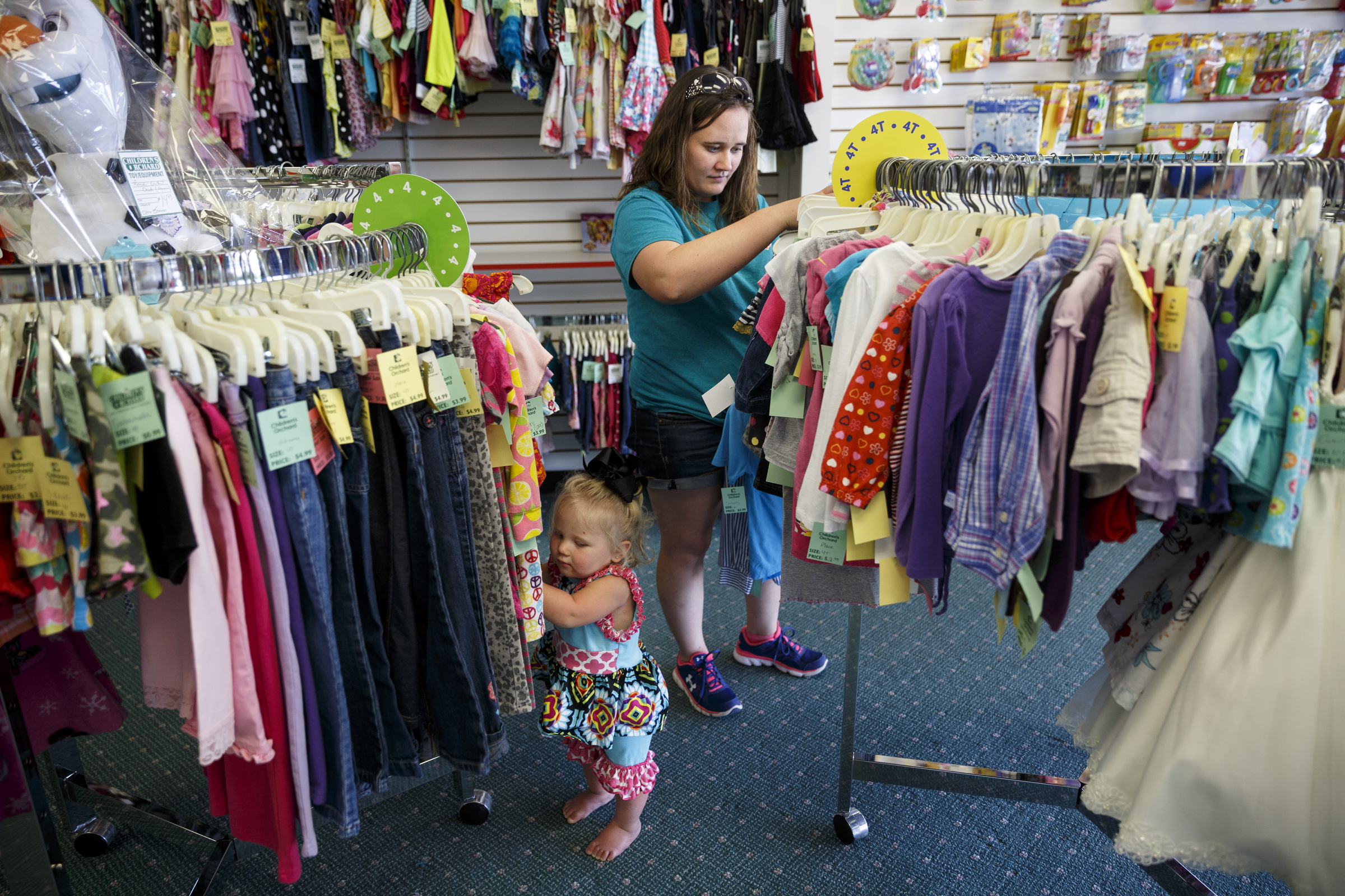 Ashley Lawson and her daughter. Elleeannah Ford, look for clothes at Children's Orchard in Cleveland, Tenn. The store sells used children's clothes, toys and accessories brought in by customers, who can swap them for credit or cash.