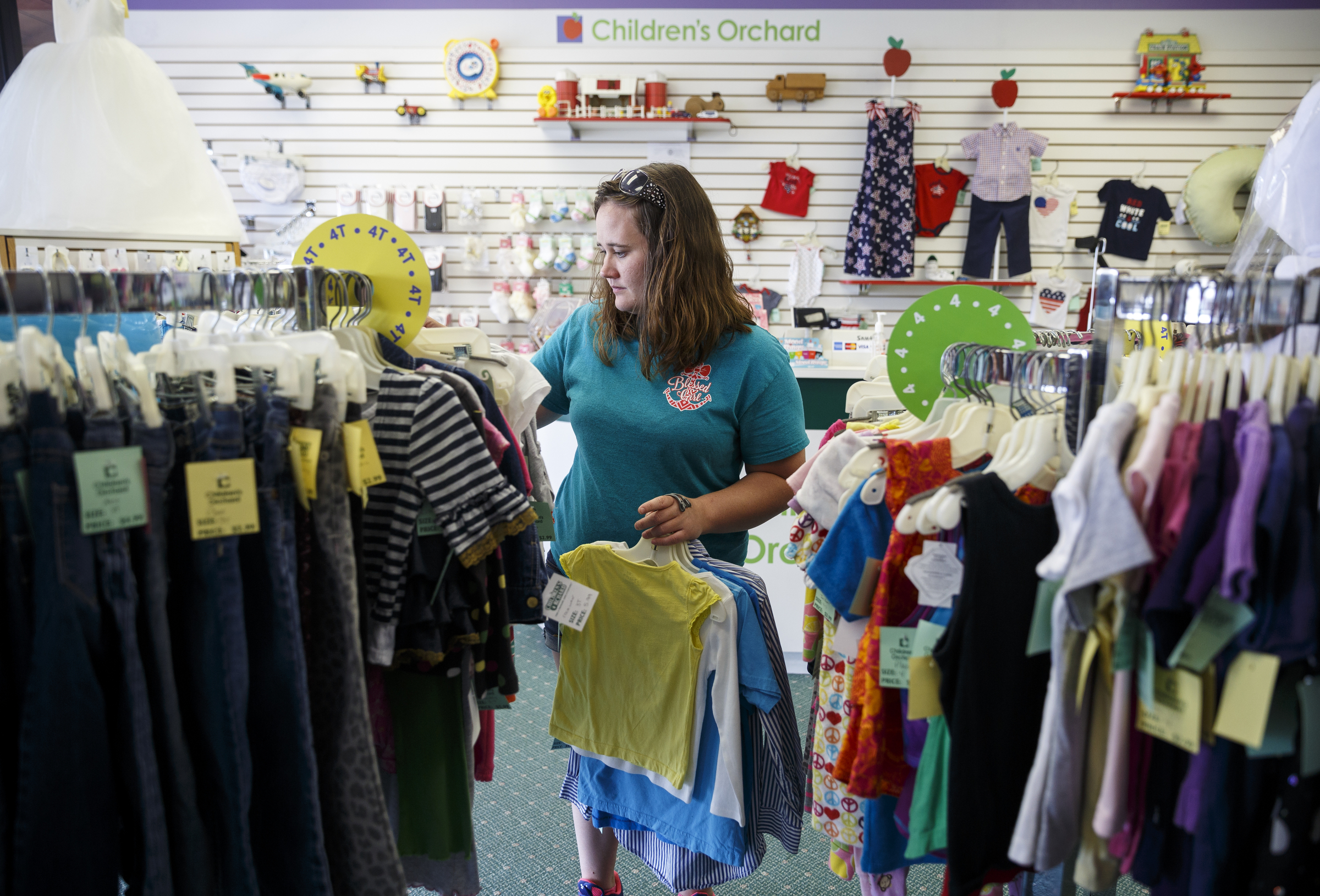 Ashley Lawson looks for clothes at Children's Orchard in Cleveland, Tenn. The store sells used children's clothes, toys and accessories brought in by customers, who can swap them for credit or cash.