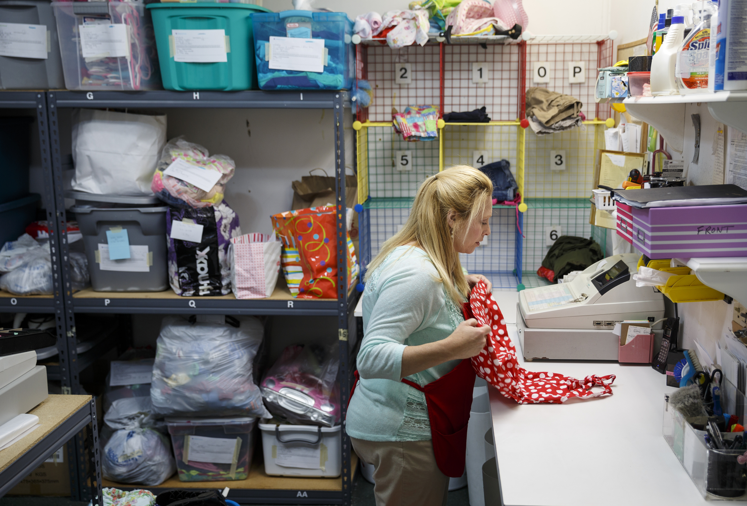Crystal Black sorts clothing to be sold at Children's Orchard in Cleveland, Tenn., which sells used children's clothes, toys and accessories brought in by customers, who can swap them for credit or cash.
