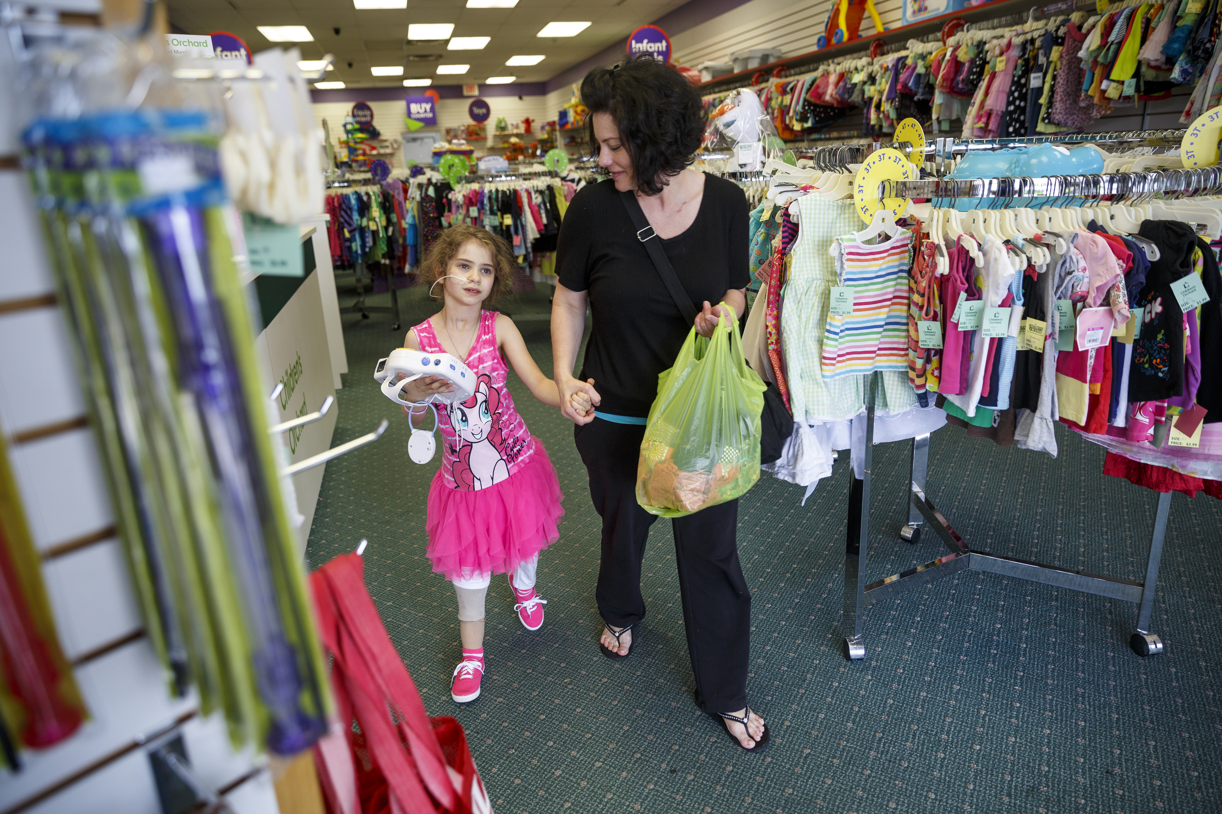 Stephanie McCallister, right, and her daughter, Jordyn, leave after shopping at Children's Orchard in Cleveland.