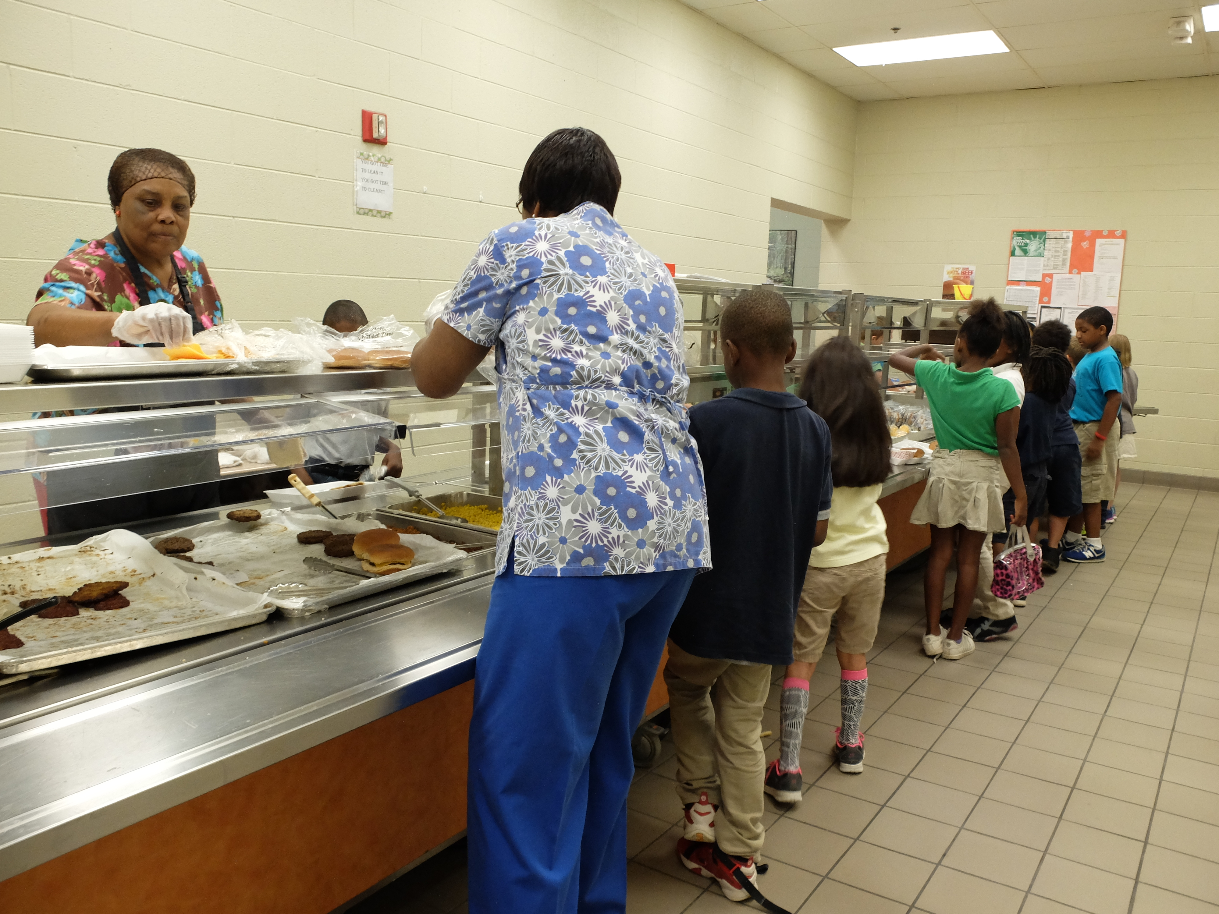 Battle Academy second grade students line up for lunch and receive help from nutrition workers Pearlie Mae Conner, left, and Josephine Marshall.
