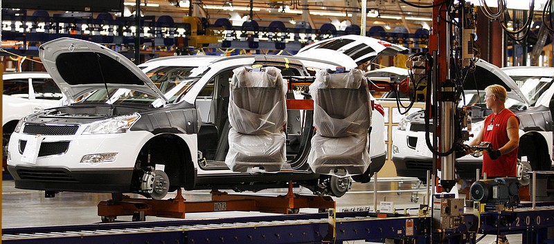 FILE - In this Oct. 3, 2008 file photo, assembly line worker Melvin Matthews, right, uses a large robotic machine to install front seats in a new 2009 Chevrolet Traverse at the GM Spring Hill Manufacturing Plant, in Spring Hill, Tenn. General Motors Corp. has narrowed down the locations, June 10, 2009, where it could build its new small car to factories in either Michigan, Tennessee or Wisconsin. (AP Photo/Bill Waugh, File)