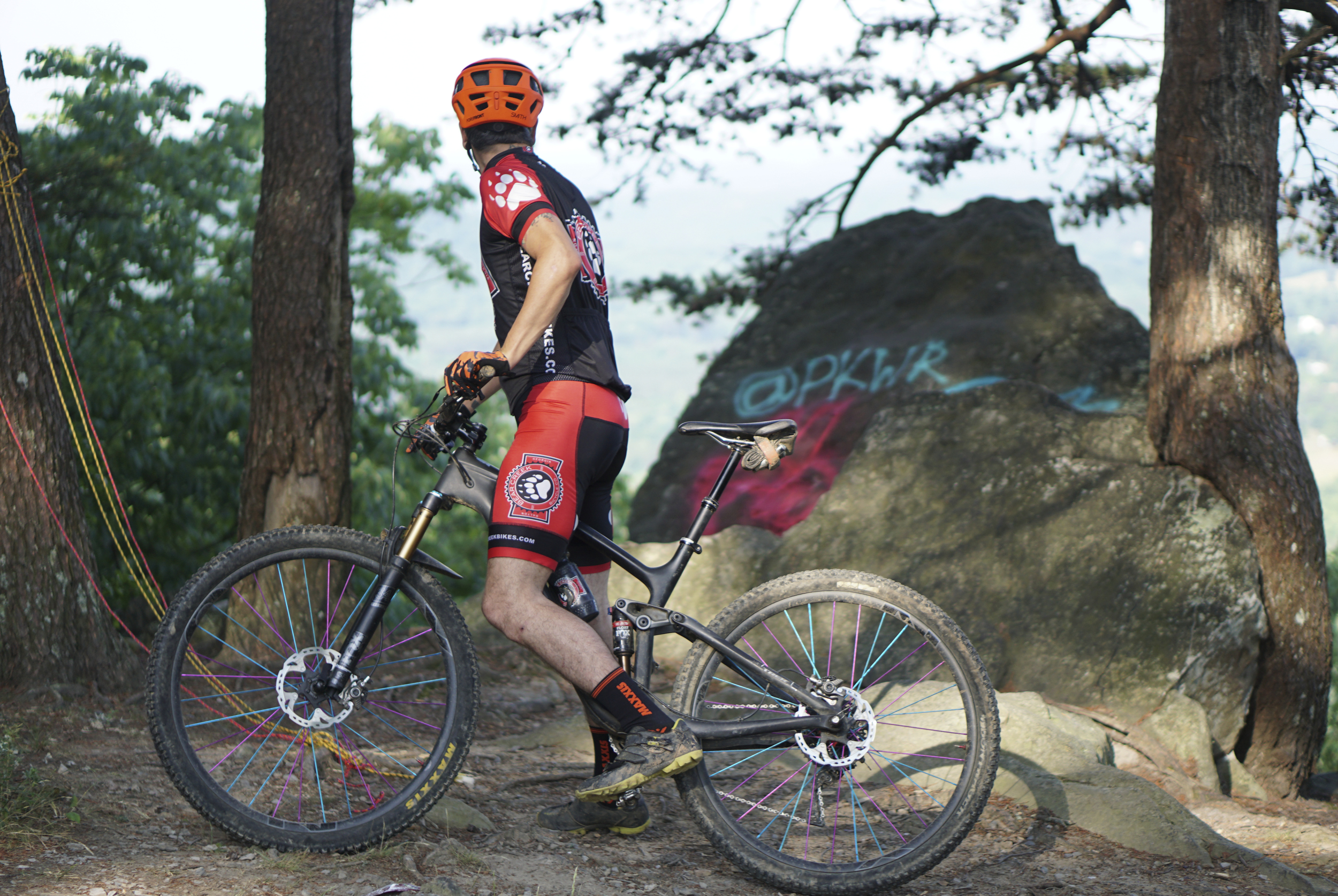 Staff Photo by Dan Henry / The Chattanooga Times Free Press- 5/25/16. Jeff Bartlett looks at recent graffiti at an overlook while riding an expert section of the Pinhoti Trail near the Dug Gap trailhead where he and other mountain bikers have seen modifications with the removal or addition of rocks to make boulder garden sections easier to ride. With a small number of expert trails in the Chattanooga area these modifications are seen as destructive and bad for the mountain biking community as a whole.