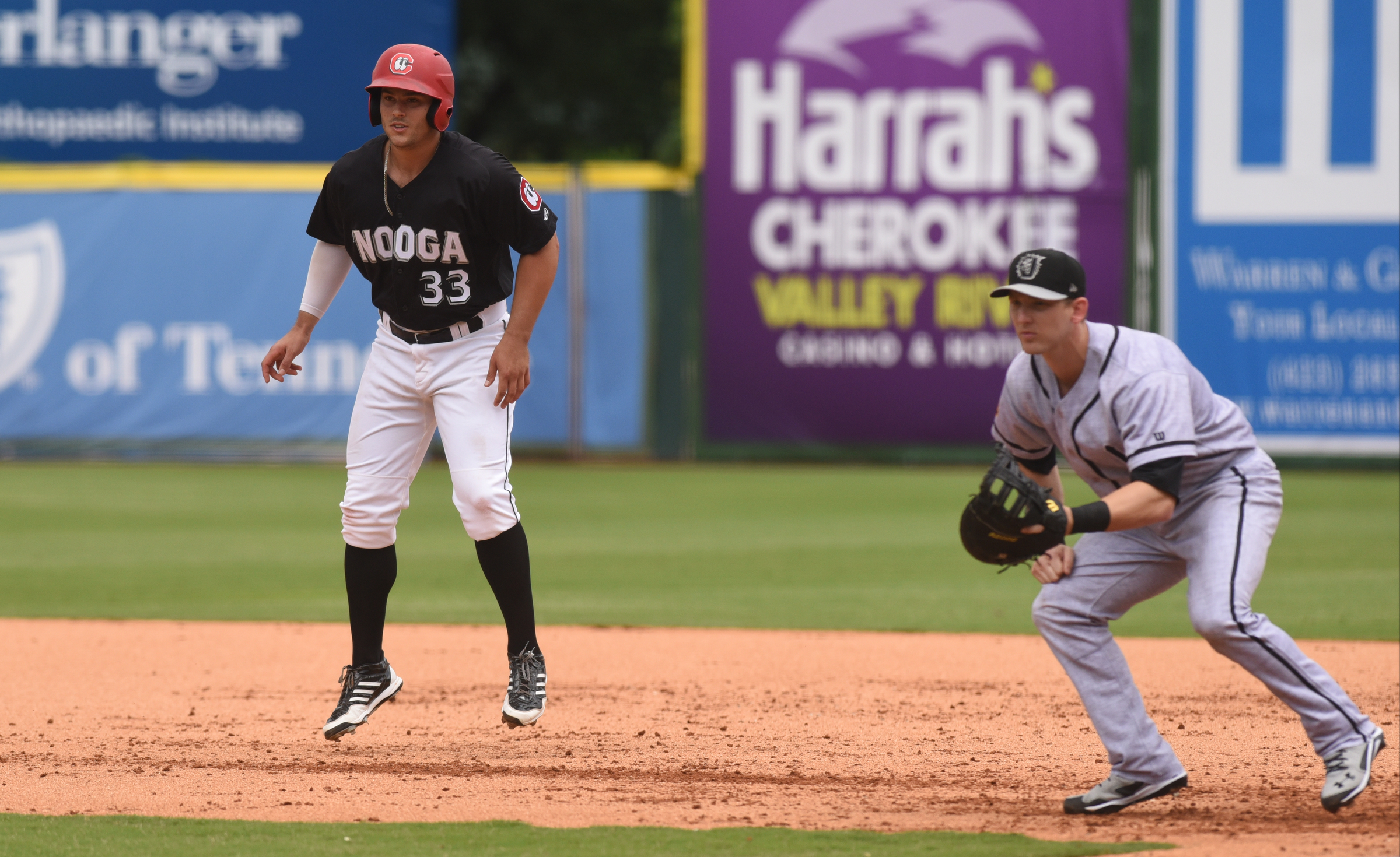 The Chattanooga Lookouts' Daniel Palka takes a lead toward second base as Jacksonville Suns first baseman Chris Curley watches the batter during Sunday's game at AT&T Field. Palka's 12 home runs lead the Southern League.
