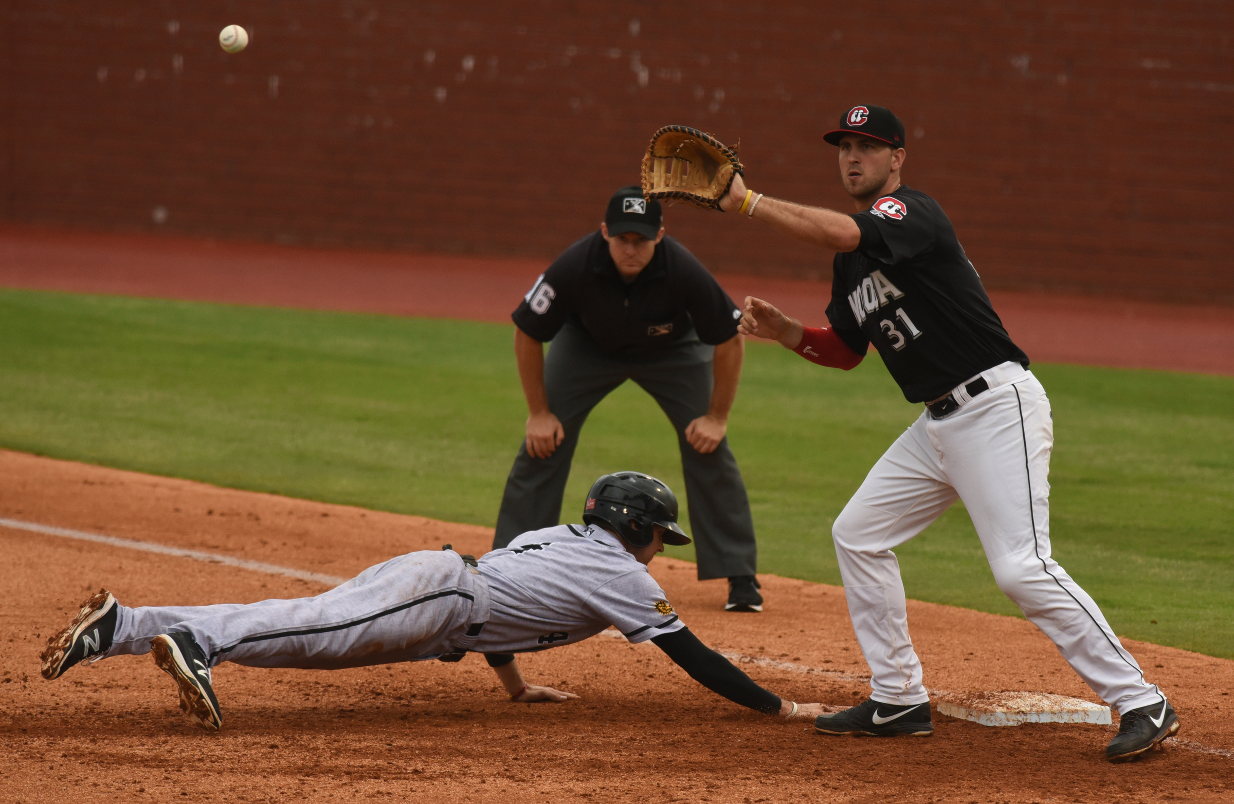 Chattanooga Lookouts first baseman D. J. Hicks waits for the throw as the Jacksonville Suns' J. T. Riddle slides back to base Sunday, June 5, 2016 at AT&T Field.