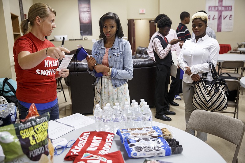 Maranda Wright, left, with Kmart, talks with Destiny Jordan, center, while Corneisha Clements waits in line at a two-day job fair and career readiness program hosted by First Things First at New Covenant Fellowship Church on Friday, June 3, 2016, in Chattanooga, Tenn. The program for high schoolers and recent graduates helps teach them how to apply for work and connect to employers.