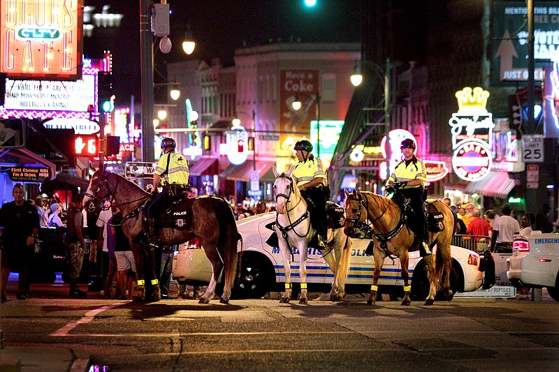 In this late Saturday, June 4, 2016, photo, Memphis Police Department mounted police close off Beale Street so investigators can work the scene where Officer Verdell Smith was struck by the fleeing vehicle of a man suspected in a downtown shooting, in Memphis, Tenn. Smith died at Regional Medical Center. (Nikki Boertman/The Commercial Appeal via AP)