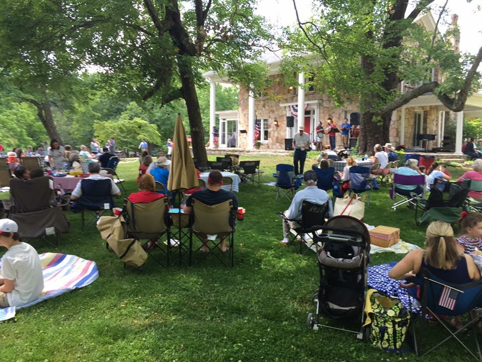 Picnic attendees are treated to live bluegrass performed on the front porch of the McCoy house.