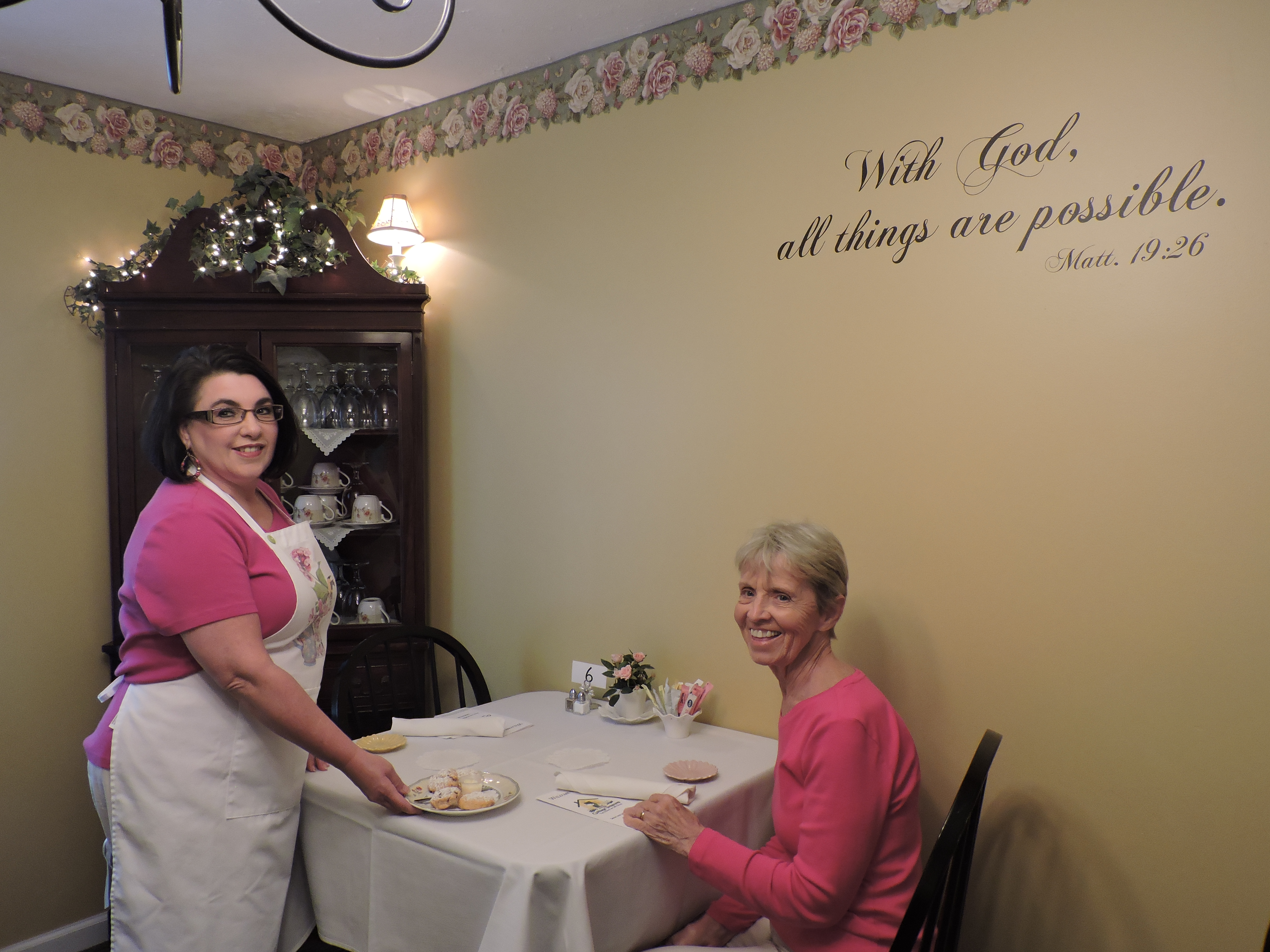 Cottage Treasures Tea Room dining room manager/server Karen Smith, left, serves Alice Marcum some scones. According to manager Bettye Ziegler, the most popular order is the sampler platter which contains a chicken salad croissant, a slice of quiche Lorraine, a house salad, a garnish with fresh fruit and a strawberry frozen tart. Scones, made fresh daily, are served on the side.