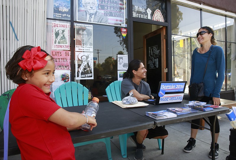 In this Thursday, May, 19, 2016, photo, Richard Avina, center, a volunteer for Democratic presidential candidate Bernie Sanders, assists Judith Ceja, with her daughter Angela to find her voting place in Boyle Heights district of Los Angeles. Bernie Sanders' campaign is mining deep into voter data from Hispanic enclaves, scouting for hidden supporters in an effort to undercut Hillary Clinton in a contest that he has vowed to fight to the end. Clinton ran up a 2-1 advantage with Hispanics in her 2008 win in California over Barack Obama and is making a strong push to do that again.