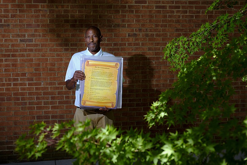 Anthony Stanton poses for a portrait with a copy of the ten commandments which he was carrying on Market Street on Wednesday, June 8, 2016, in Chattanooga, Tenn.