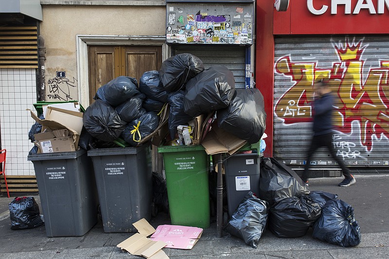 
              In this picture taken with a long time exposure, a man walks past a pile of rubbish bags in Paris, France, Wednesday June 8, 2016. After a rough couple of months which have included protests, fuel shortages, rail strikes and once-in-a-generation floods, France's capital is facing a new challenge : Piles of uncollected trash. A new wave of strikes is disrupting trash collection in Paris with only two days to go until the European Championship soccer tournament, a sporting event predicted to draw 2.5 million spectators. (AP Photo/Kamil Zihnioglu)
            