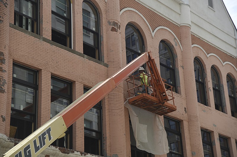 John Gilbreath works near the windows of a building at the corner of 8th and Broad Streets Tuesday, May 31, 2016.