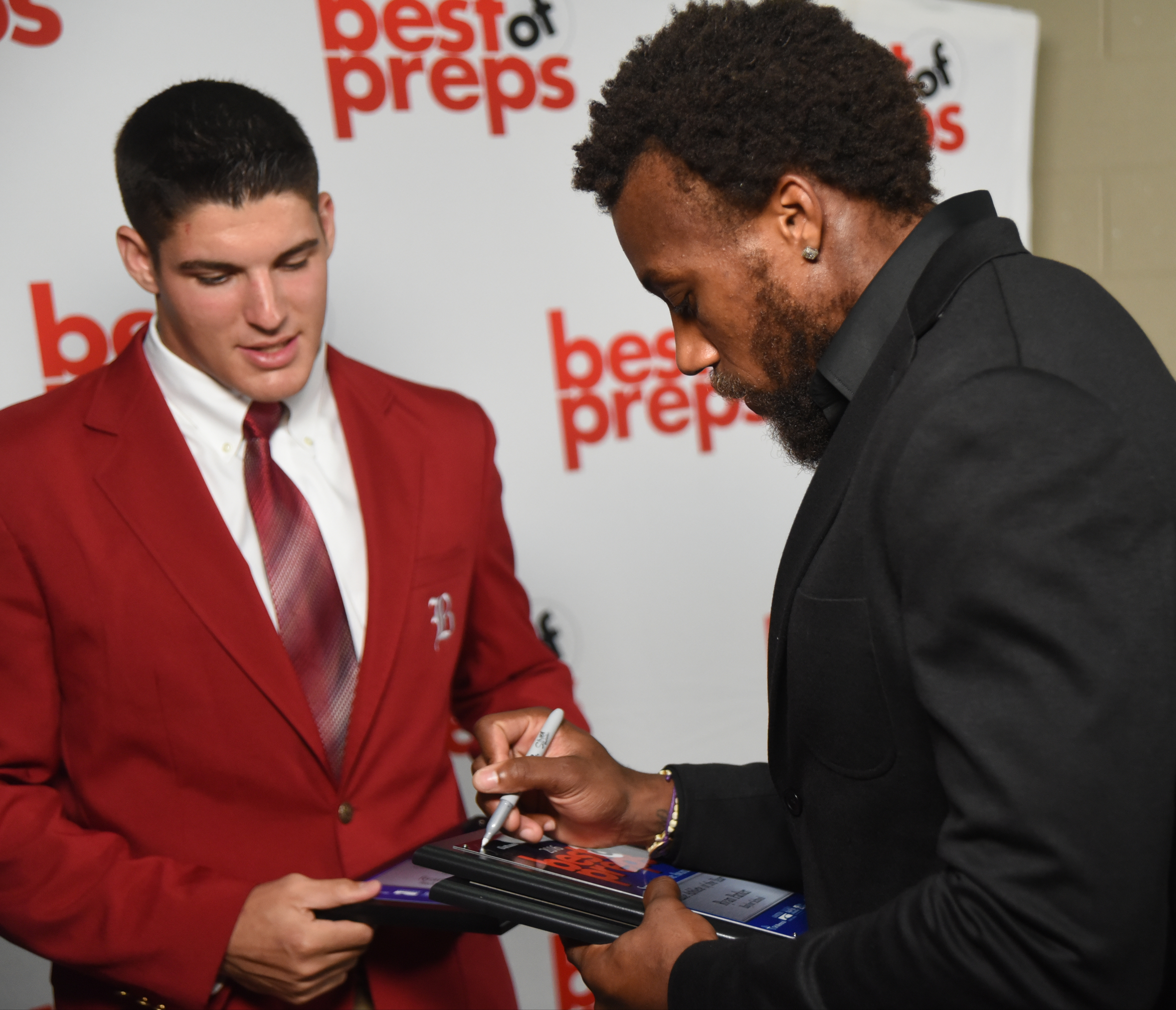 Kansas City Chiefs defensive back Eric Berry signs Baylor's Ryan Parker's awards after the Best of Preps banquet Thursday night at the Chattanooga Convention Center. Parker won three awards, including the Scrappy Moore Boys' Athlete of the Year.