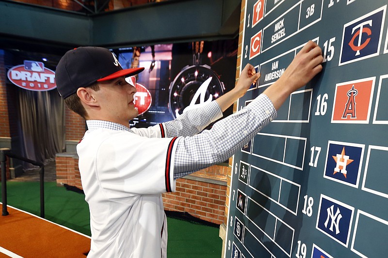 Ian Anderson, a pitcher from Shenendehowa High School in Clifton Park, N.Y., puts his name on the board after being drafted No. 3 by the Atlanta Braves in the first round of the baseball draft, Thursday, June 9, 2016, in Secaucus, N.J. (AP Photo/Julio Cortez)
