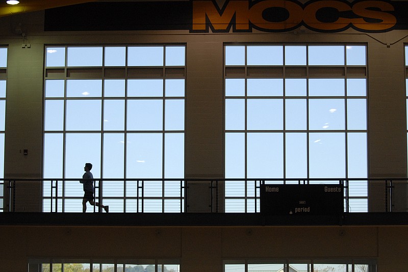 A UTC student runs around the perimeter of the indoor track at the UTC Aquatic and Recreation Center.