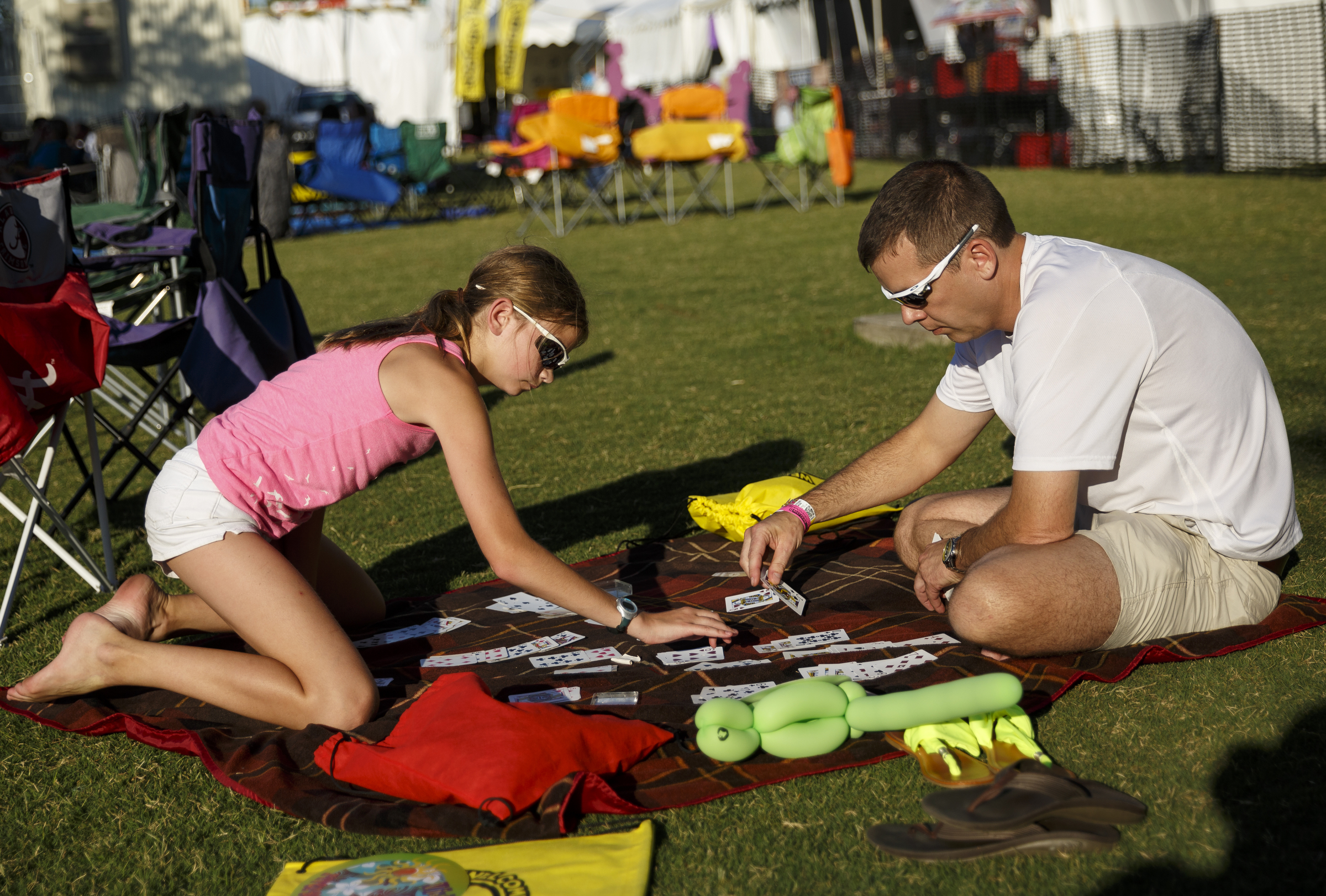 Shawn Petree, right, and his daughter Lily play cards on the 1st day of the Riverbend Festival at Ross's Landing on Friday, June 10, 2016, in Chattanooga, Tenn. The festival is celebrating its 35th year, and Thomas Rhett was Friday night's headlining act.