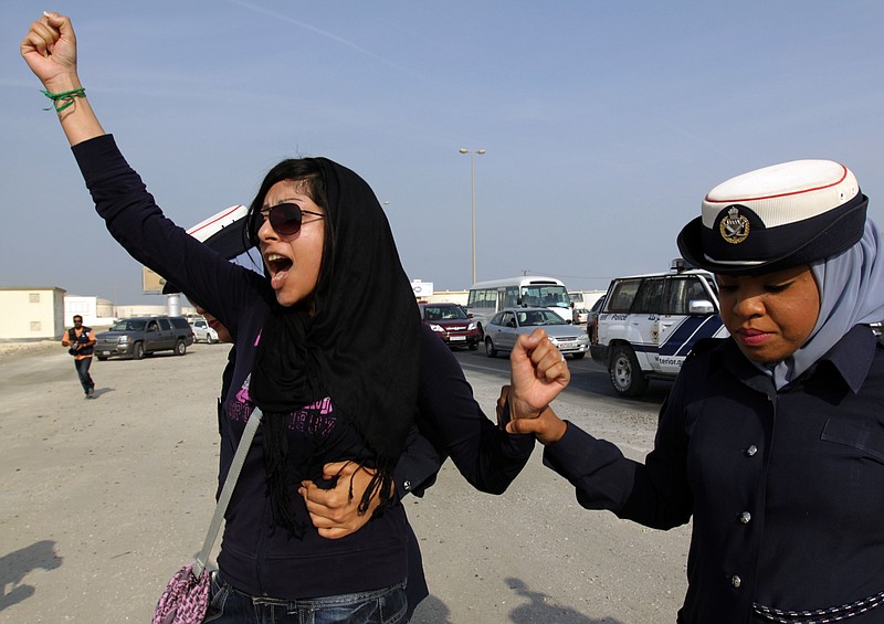 
              FILE -- In this Oct. 21, 2012 file photo, Bahraini opposition activist Zainab al-Khawaja, left, gestures as she shouts "God is greater than any tyrant," while being arrested by police officers in Eker, Bahrain. The prominent activist says she's left Bahrain with her two children for Denmark after being recently released from prison. Zainab al-Khawaja is the daughter of well-known activist Abdulhadi al-Khawaja, who is serving a life sentence over his role in Arab Spring-inspired protests by its Shiite majority in 2011. (AP Photo/Hasan Jamali, File)
            