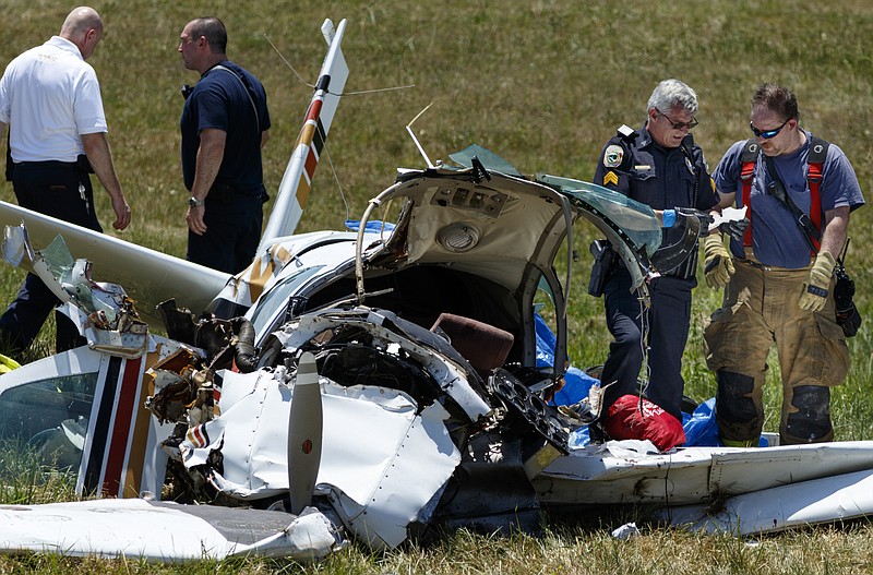 Emergency responders and and investigators work the scene of a plane crash next to the runway of the Collegedale Municipal Airport on Saturday, June 11, 2016, in Collegedale, Tenn. There were 2 fatalities, and 2 victims were airlifted to Erlanger Hospital for treatment.