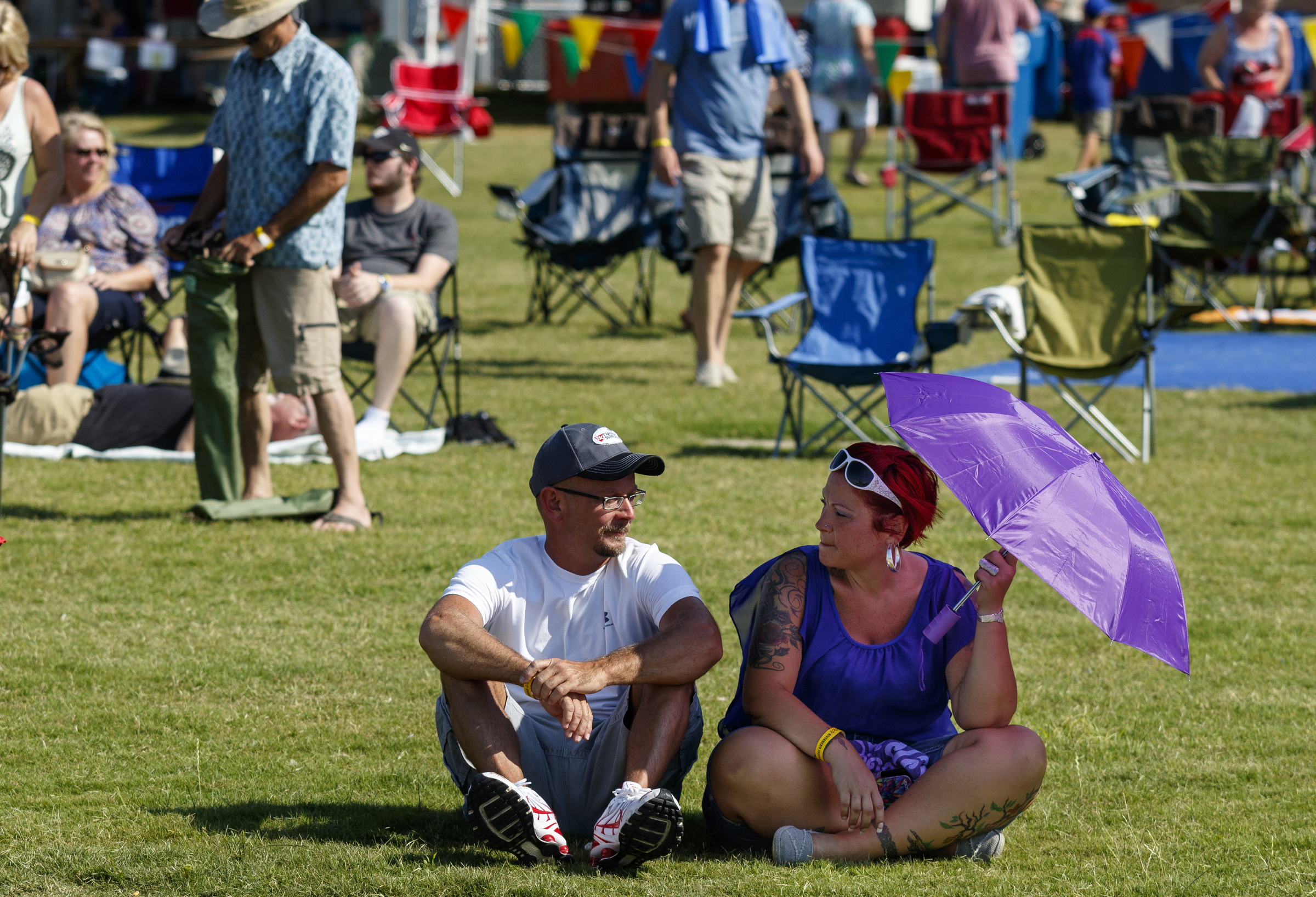 Jenny Deluca, right, and David Haney take shelter from the sun beneath an umbrella on the 2nd day of the Riverbend Festival at Ross's Landing on Saturday, June 11, 2016, in Chattanooga, Tenn. Rock band Heart headlined Saturday night.