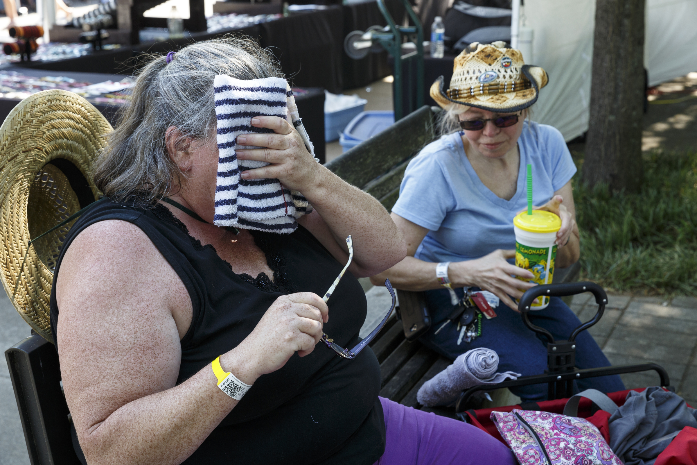 Nicci Baierlein, left, and Chrystal Crane try to keep cool as temperatures rise into the high 90s on the 2nd day of the Riverbend Festival at Ross's Landing on Saturday, June 11, 2016, in Chattanooga, Tenn. Rock band Heart headlined Saturday night.