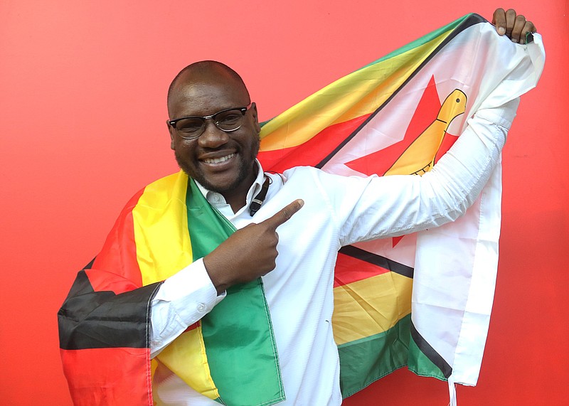 
              This photo taken Tuesday May 3, 2016 shows Evans Mawarire, a young pastor, posing with a Zimbabwean flag wrapped around his body, in Harare.  Mawarire launched a media campaign called Thisflag" to protest alleged government failures and asserting the meaning of the national emblem. (AP Photo/Tsvangirayi Mukwazhi)
            