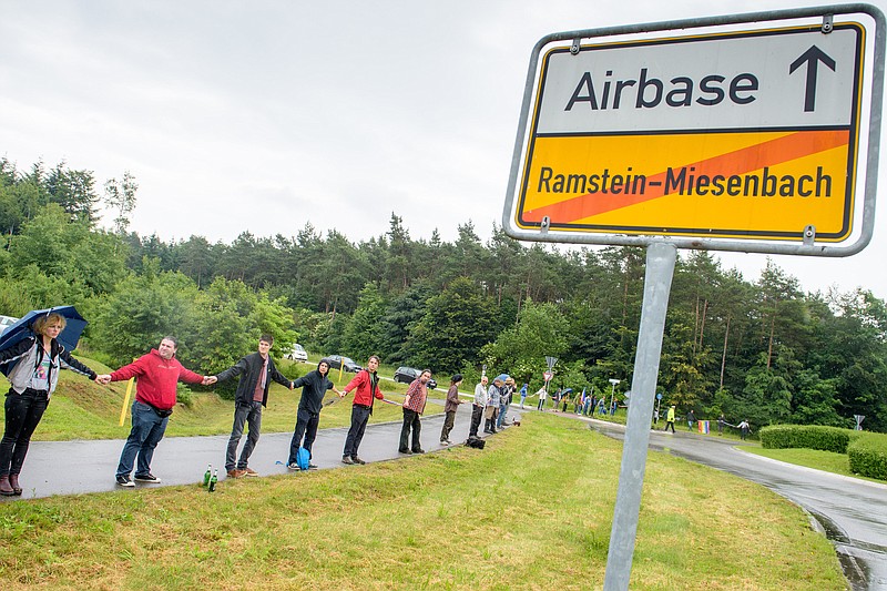 
              Peace activists form  a human chain on the street leading towards the US air base during the 'Stopp-Ramstein' campaign in Ramstein,  Germany, Saturday June 11, 2016. Demonstrators have formed a human chain near  the  U.S. air base in western Germany to protest against lethal drone  strikes.  Protest organizers contend that the Ramstein Air Base is used to relay flight control data for lethal drone strikes. They are calling for the base, a major U.S. military hub, eventually to be closed altogether.   (Oliver Dietze/dpa via AP)
            