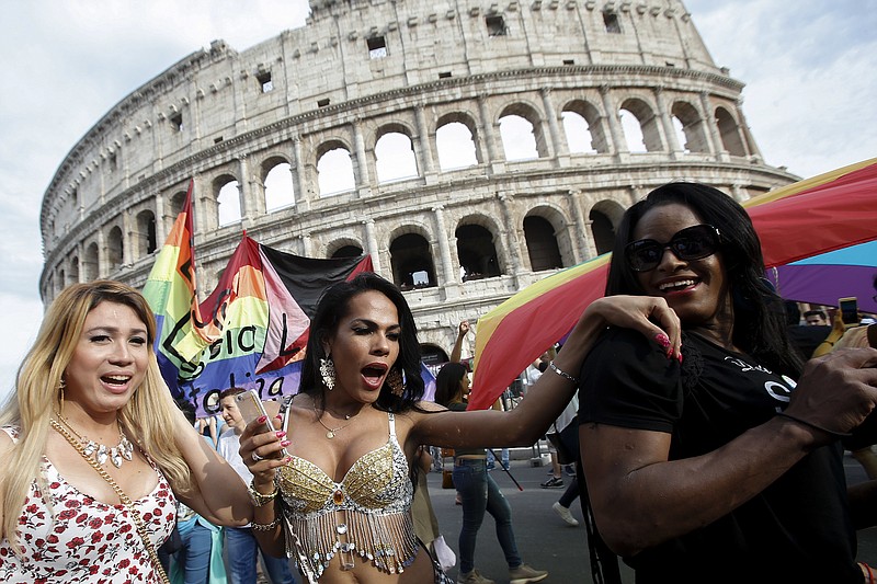 
              People march past the Colosseum during the Gay Pride parade in Rome, Saturday, June 11, 2016. Italy joined the rest of Europe last month in giving some legal rights to gay couples after a years-long battle and opposition from the Catholic Church to anything that smacked of authorizing gay marriage. (AP Photo/Fabio Frustaci)
            