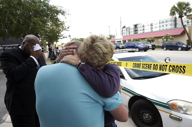 
              Terry DeCarlo, executive director of the LGBT Center of Central Florida, center, is comforted by Orlando City Commissioner Patty Sheehan, right, after a shooting involving multiple fatalities at a nightclub in Orlando, Fla., Sunday, June 12, 2016. (AP Photo/Phelan M. Ebenhack)
            