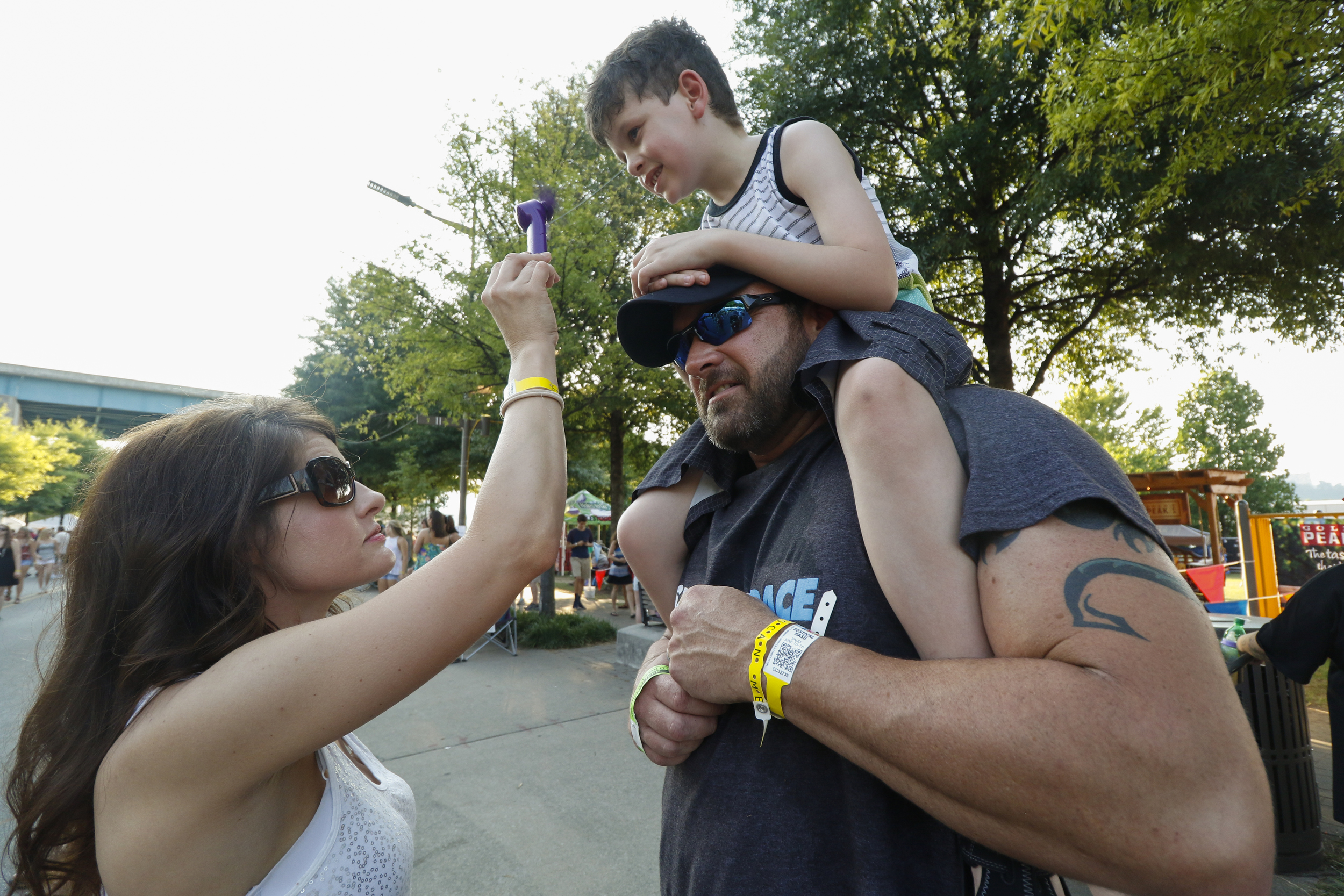 Staff Photo by Dan Henry / The Chattanooga Times Free Press- 6/12/16. Amber Gardenhire cools down nine-year-old Maddox Gardenhire and Randall Gardenhire with a mini fan during the 2016 Riverbend Music Festival in downtown Chattanooga on Sunday, June 12, 2016. This is the 35th year of the festival.