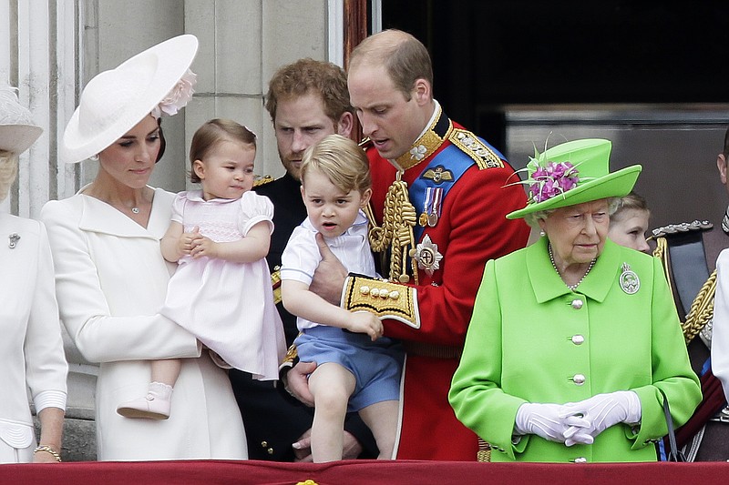 
              Britain's Queen Elizabeth II, right, with Prince William holding Prince George, centre, and Kate, Duchess of Cambridge holding Princess Charlotte, left, on the balcony during the Trooping The Colour parade at Buckingham Palace, in London, Saturday, June 11, 2016.  Hundreds of soldiers in ceremonial dress have marched in London in the annual Trooping the Colour parade to mark the official birthday of Queen Elizabeth II. The Trooping the Colour tradition originates from preparations for battle, when flags were carried or "trooped" down the rank for soldiers to see. (AP Photo/Tim Ireland)
            