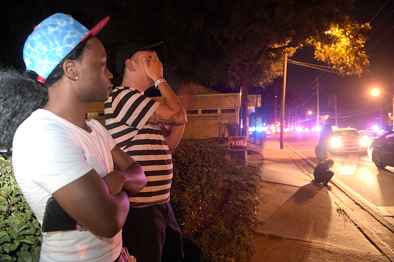 Jermaine Towns, left, and Brandon Shuford wait down the street from a multiple shooting at a nightclub in Orlando, Fla., Sunday, June 12, 2016. Towns said his brother was in the club at the time. A gunman opened fire at a nightclub in central Florida, and multiple people have been wounded, police said Sunday. (AP Photo/Phelan M. Ebenhack)