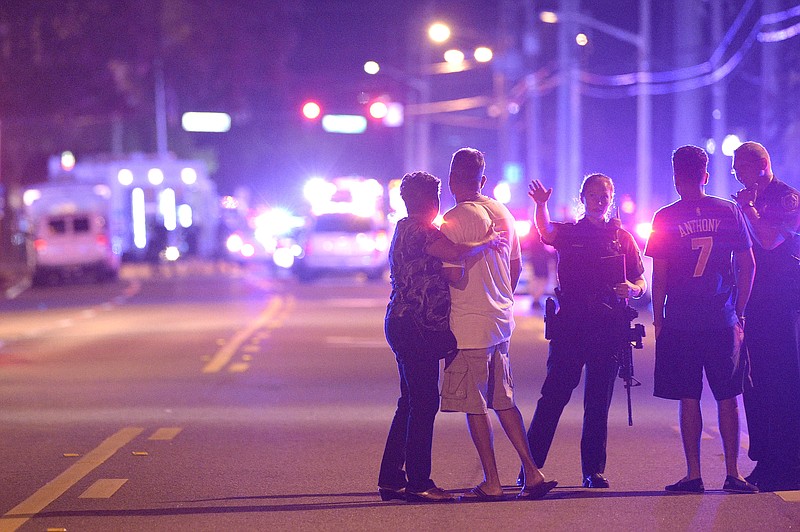 
              Orlando Police officers direct family members away from a multiple shooting at a nightclub in Orlando, Fla., Sunday, June 12, 2016. A gunman opened fire at a nightclub in central Florida, and multiple people have been wounded, police said Sunday. (AP Photo/Phelan M. Ebenhack)
            