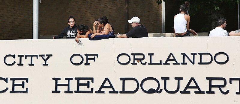 Concerned friends and family of victims at the Pulse nightclub, where multiple fatalities were reportedly after a shooting, wait outside of the Orlando Police Department, Sunday, June 12, 2016, in Orlando, Fla. (Joe Burbank/Orlando Sentinel via AP)