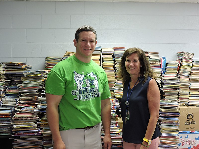 Gilbert Elementary School Principal Matt Harris and Assistant Principal Tammy Leen stand in a room full of books. The school's media center is undergoing a renovation this summer. The books will return to the walls after renovations are complete.