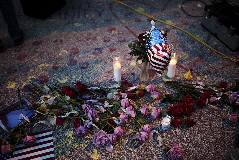 A makeshift memorial left nearby Pulse nightclub at dawn in Orlando, Fla., Monday. Dozens of bodies were removed overnight from the popular gay club as investigators tried to piece together what had led to a shooting rampage 24 hours earlier that left 50 people dead, including the gunman, and 53 wounded. (Hilary Swift/The New York Times)