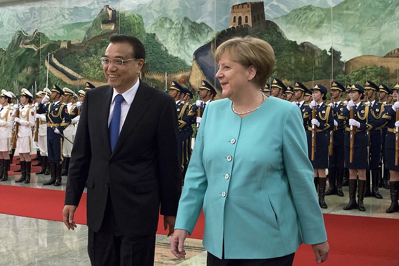 
              Germany's Chancellor Angela Merkel, right, chats with China's Premier Li Keqiang during a welcome ceremony at the Great Hall of the People in Beijing, Monday, June 13, 2016. (AP Photo/Andy Wong)
            