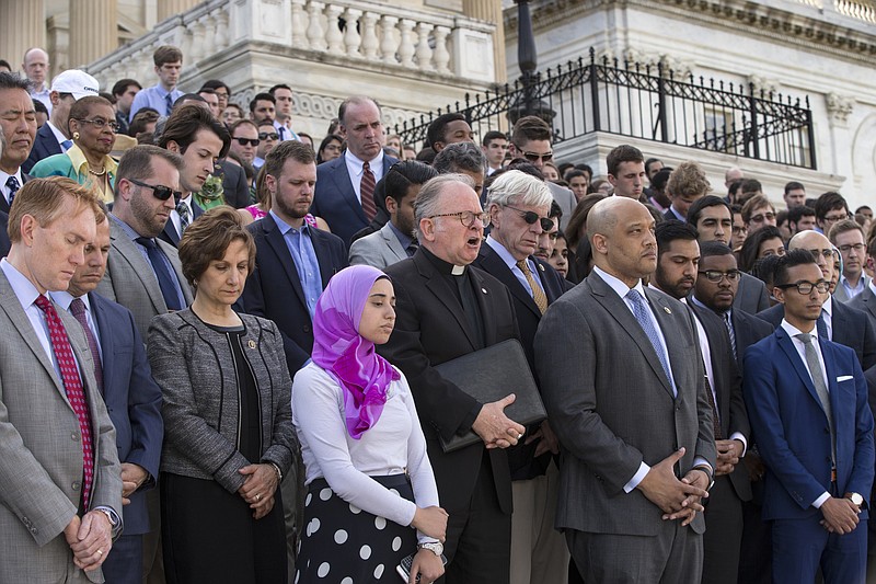 
              Members of Congress join the LGBT Congressional Staff Association and the Congressional Muslim Staff Association for a prayer and moment of silence on the steps of the Capitol to stand in solidarity with the Orlando community and to remember the victims of Sunday's shooting at an LGBT night club, in Washington, Monday, June 13, 2016. Father Patrick J. Conroy, center, chaplain of the House of Representatives, delivered an interfaith message. (AP Photo/J. Scott Applewhite)
            