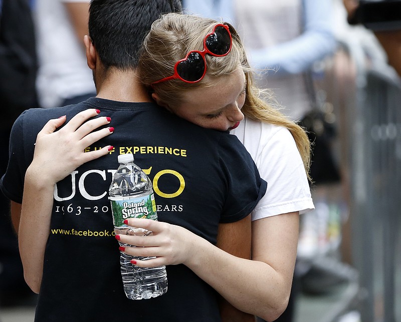 
              A young woman and man embrace during a vigil and memorial for victims of the Orlando nightclub shootings at the historic Stonewall Inn Monday, June 13, 2016, in New York. State and city officials, LGBT community members, and others gathered as a show of solidarity with the victims and survivors of the Orlando nightclub shootings. (AP Photo/Kathy Willens)
            