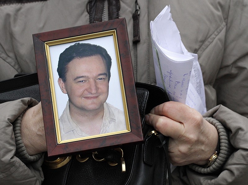 
              FILE - In this Nov. 30, 2009, file photo a portrait of lawyer Sergei Magnitsky, who died in jail, is held by his mother Nataliya Magnitskaya, as she speaks during an interview with the AP in Moscow. A documentary premiering June 13, 2016, at Washington’s Newseum is generating controversy by claiming that late Russian whistleblower Magnitsky, who had inspired a major U.S. human rights law, was responsible for the very fraud he had accused Russian officials of perpetrating. (AP Photo/Alexander Zemlianichenko, File)
            