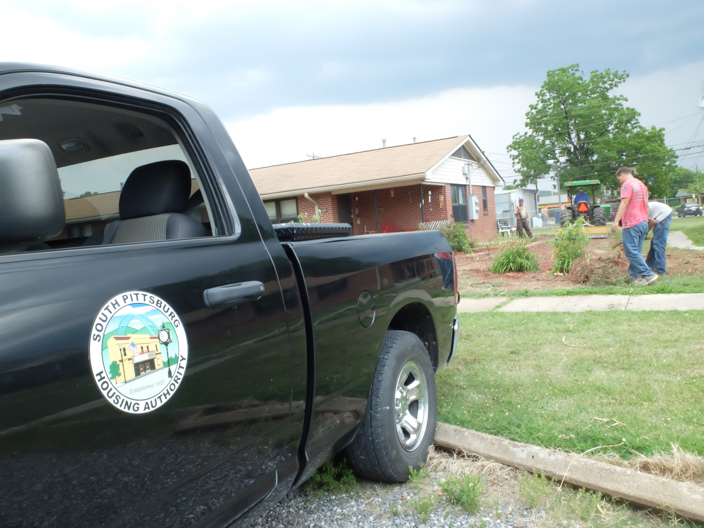 Dirt work continues Tuesday as a South Pittsburg Housing Authority crew works to restore the lawn at 103 Elm Ave. where the resident had a flower garden that encompassed the entire property.