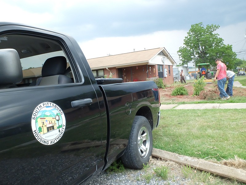 Dirt work continues Tuesday as a South Pittsburg Housing Authority crew works to restore the lawn at 103 Elm Ave. where the resident had a flower garden that encompassed the entire property.